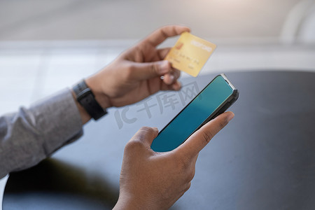 网上购物和互联网支付，亚洲男性正在使用手机和信用卡在数字世界中网上购物或办事。