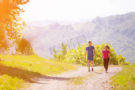 年轻夫妇在阳光明媚的日子在大自然中慢跑