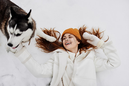 一个女人冬衣在雪地里遛狗的肖像