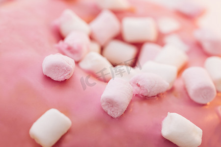 关闭粉红色和白色迷你棉花糖在粉红色甜甜圈食品清淡的甜点糖果美味的糖。