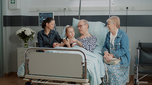 老人和侄女在医院病床上用智能手机浏览互联网