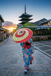 日本京都八坂塔和三年坂街穿着日本传统和服、带伞的女子。