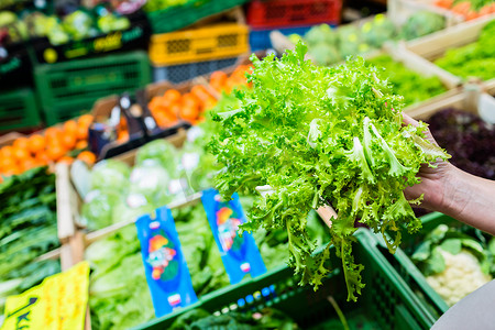 市场摊位摄影照片_顾客在市场摊位购买沙拉和蔬菜