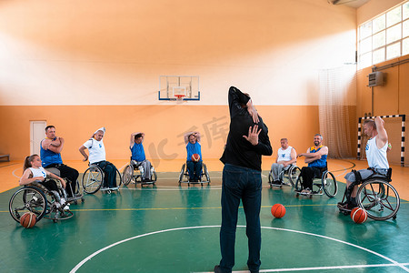 残疾篮球队选拔员站在球员面前，向他们展示训练开始前的伸展运动