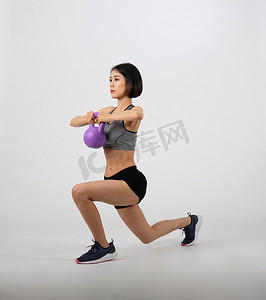 穿着运动服、拿着壶铃在白色背景上进行健身锻炼的运动型女人。