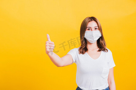 戴口罩保护的妇女，显示拇指手指很好地阻止了病毒爆发控制