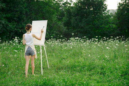 围裙中的女艺术家油漆调色板画架自然