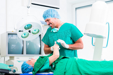 手术室里的外科医生握着病人的手