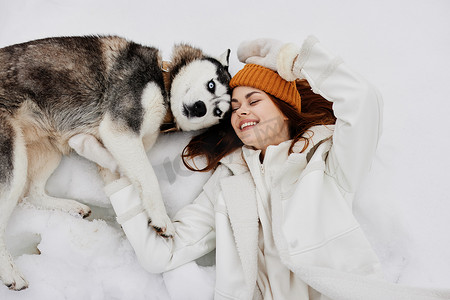 一个女人冬装在雪地新鲜空气中遛狗的肖像