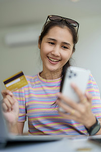 网上购物和互联网支付，美丽的亚洲女性肖像正在使用信用卡和手机在网上购物或在数字世界中办事