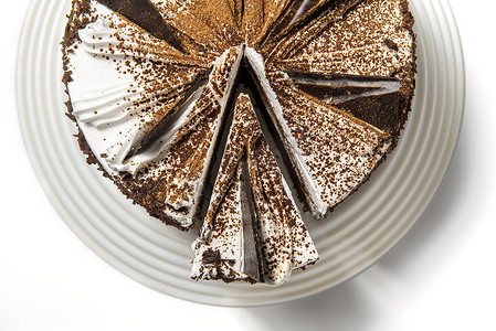 蛋糕用巧克力，撒上巧克力片，放在白色背景的托盘上，上面有切好的碎片。