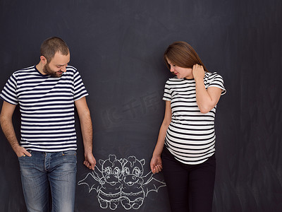 怀孕夫妇在黑板上画出他们的想象力