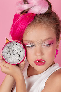 红色火龙果摄影照片_漂亮女孩的特写肖像，有粉红色的发型，粉红色的背景上有火龙果。