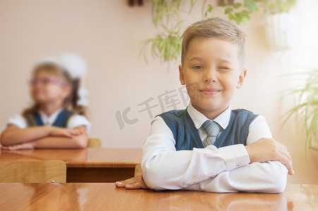男孩子摄影照片_坐在书桌前的快乐男小学生