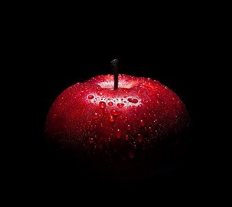 黑色背景下有水滴的新鲜红苹果