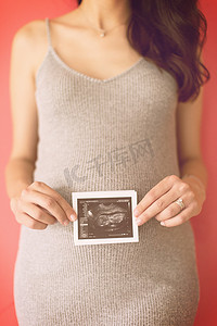 胎儿图片摄影照片_显示超声波图片的快乐孕妇