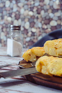 分割线黄色摄影照片_木桌上一盘西班牙土豆煎蛋卷切成八分之一的高视图。