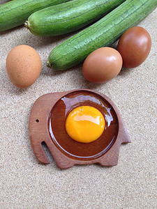 兰象形字摄影照片_木制象形碟上的蛋黄蛋，配有鸡蛋和角