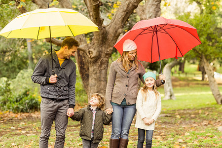 微笑的年轻家庭在伞下