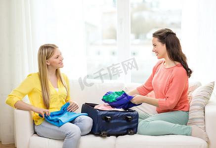 两个微笑的少女在家收拾行李