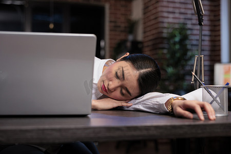 精疲力尽的机构工作人员在做项目时在办公室工作区睡着了。