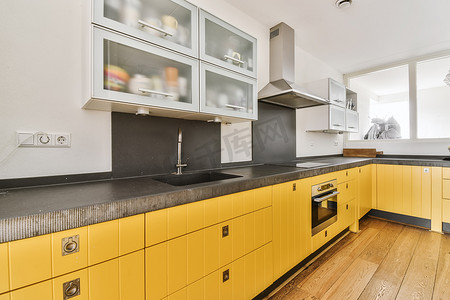 吊柜摄影照片_有黄色厨房单元和吊柜的漂亮厨房