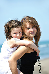 女孩与母亲合影摄影照片_海滩上孩子们与老师的合影