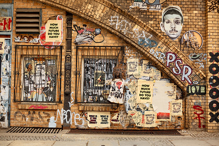 贫民区，墙壁上画满了涂鸦，窗户在铁栅后面。