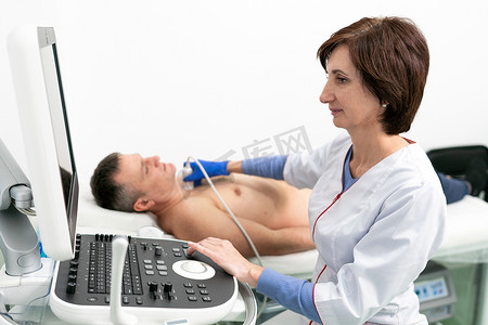 医生在心脏病诊所对男性患者进行多普勒超声检查。