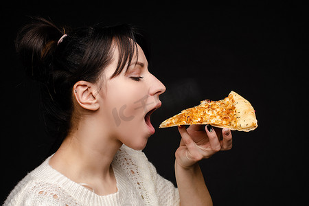 饥饿的年轻女子张开嘴准备咬开胃披萨的特写脸