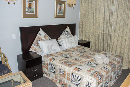 酒店房间双床摄影照片_豪华酒店房间，床上有漂亮的窗帘和毛巾