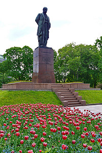 花坛背景上的塔拉斯舍甫琴科纪念碑，上面有美丽的红色郁金香