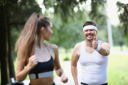 朋友跑步摄影照片_疲惫的中年男子清晨与女性朋友跑步