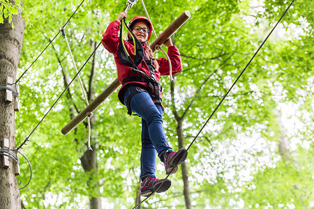 儿童到达高空绳索课程的平台攀爬