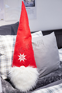 坐在枕头上摄影照片_可爱的斯堪的纳维亚圣诞矮人坐在枕头上。