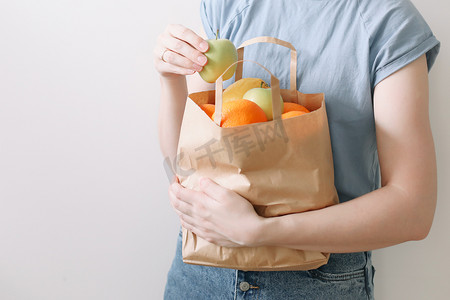 购物、健康饮食和生态友好概念 — 妇女拿着白色背景水果的生态袋的特写
