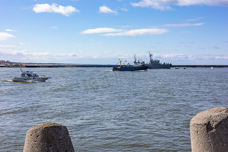 一艘军舰和船只驶过俄罗斯加里尼格勒地区波罗的斯克海湾，靠近波罗的海。
