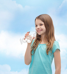 小女孩喝水摄影照片_微笑的小女孩拿着一杯水