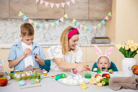 复活节恐龙彩蛋摄影照片_幸福的家庭为复活节做准备。
