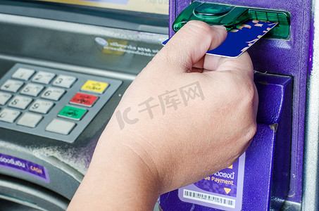手动将 ATM 信用卡插入银行机器