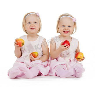 两个同卵双胞胎女孩在玩苹果