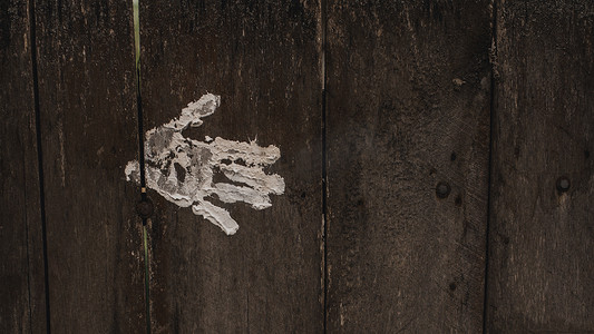旧破旧的木灰板上的白色手掌和指纹