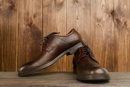 木质背景中时尚男式经典棕色鞋