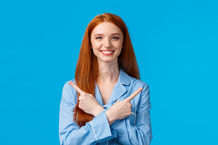 快乐的女孩广告展示两种产品、方式或选择，双手交叉指向左右两侧，高兴地微笑，穿着睡衣，可爱的睡衣，站立蓝色背景