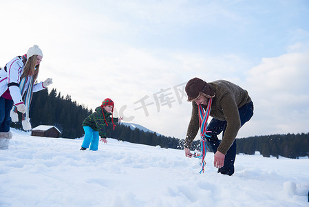 雪地里玩耍摄影照片_冬天幸福的一家人一起在雪地里玩耍