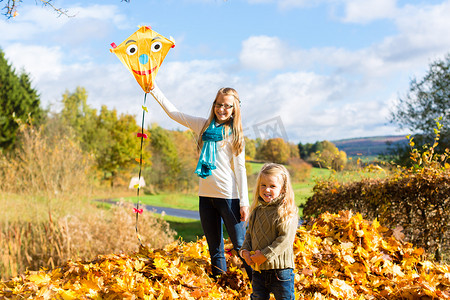 女孩们在秋天或秋天公园里放风筝玩得开心