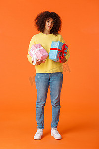 全长垂直镜头阴沉而不满，挑剔的非洲裔美国女友对寒假礼物的数量感到不满，拿着两盒盒装礼物，表情不满