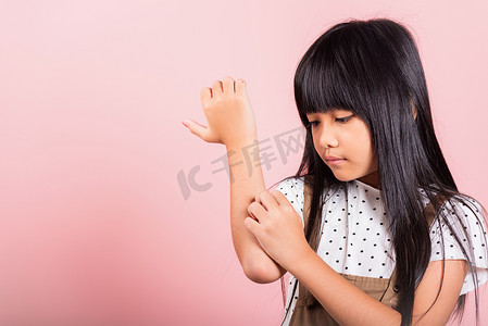10 岁的亚洲小孩因蚊子叮咬而抓痒手臂