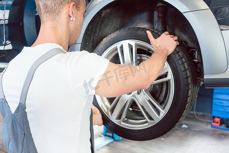 熟练汽车机械师握轮胎的手的低角度视图