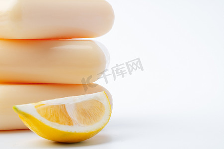 化妆品制造摄影照片_手工制造肥皂块和柠檬在白色背景。